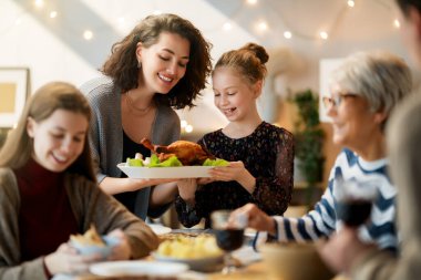 Şükran Günü, Sonbahar ziyafeti. Masada oturup bayramı kutlayan mutlu bir aile. Geleneksel yemek. Büyükanne, anne ve çocuklar. 