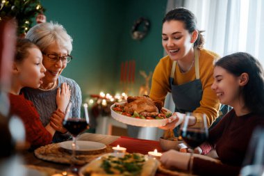 Mutlu noeller. Mutlu aile evde yemek yiyor. Kutlama tatili ve ağacın yakınındaki birliktelik.