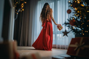 Noel ağacının yanında mutlu genç bir kadın..