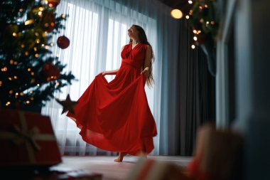 Noel ağacının yanında mutlu genç bir kadın..