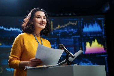 A young woman is giving a presentation at a conference.