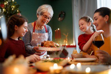 Mutlu noeller. Mutlu aile evde yemek yiyor. Kutlama tatili ve ağacın yakınındaki birliktelik.