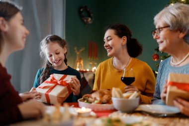 Mutlu noeller. Mutlu aile evde yemek yiyor. Kutlama tatili ve ağacın yakınındaki birliktelik.