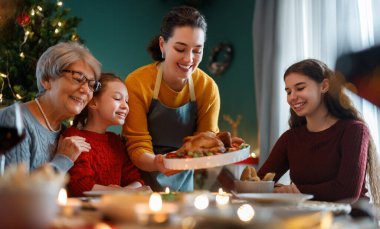 Mutlu noeller. Mutlu aile evde yemek yiyor. Kutlama tatili ve ağacın yakınındaki birliktelik.