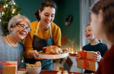 Mutlu noeller. Mutlu aile evde yemek yiyor. Kutlama tatili ve ağacın yakınındaki birliktelik.