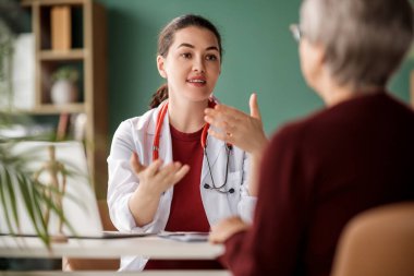 Hastanedeki bir doktoru dinleyen kadın hasta..