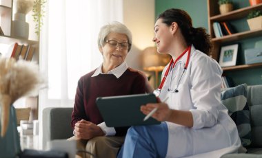 Kadın hasta içeride doktorla konuşuyor..