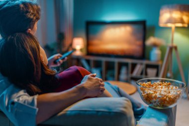 Mutlu bir aile televizyon seyrediyor, akşamları evde film seyrediyor. Çiftler birlikte vakit geçiriyorlar..