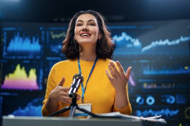A young woman is giving a presentation at a conference.