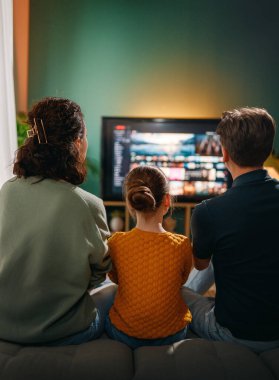 Mutlu aile birlikte vakit geçiriyor. Anne, baba ve çocuk televizyon seyrediyor, akşamları evde film seyrediyor..