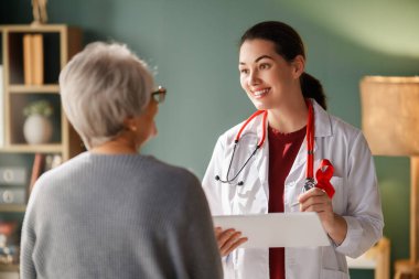 Hastalık farkındalığı konsepti için renk şeridi. Kadın hasta, muayenehanedeki doktoru dinliyor. Hastalıkla yaşayan insanlar hakkında bilgi toplamak.