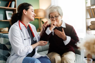 Üşütmüş bir kadın. Hasta adam kanepede oturuyor.