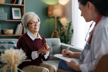 Kadın hasta içeride doktorla konuşuyor..