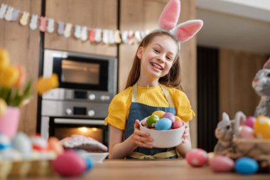 Tavşan kulaklı neşeli bir kız olarak Paskalya ruhuyla neşe saçmak canlı yumurtalarla süslemeyi sever. Samimi mutfak dekorasyonu bu neşeli bayram anına sıcaklık katıyor..