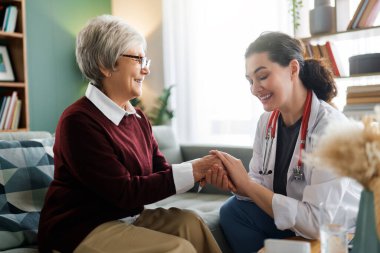 Gülümseyen bir tıp uzmanının evde yaşlı bir kadına şefkatli bir bakım ve destek sağlaması çok sevindirici. Sahne güvenin, empatinin ve sağlık hizmetlerinin özünü rahat bir ortamda yakalıyor ve avatarın önemini vurguluyor.