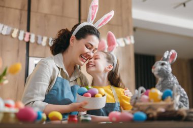 Tavşan kulağı takan neşeli anne ve kız Paskalya için hazırlanırken kucaklaşıyorlar. Aile rengarenk bir mutfak ortamında renkli yumurtaların üzerine bağlanıyor. Özel bir bayram geleneğinin sıcaklığını, sevgisini ve neşeli ruhunu yansıtıyor..