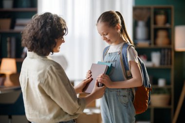 İlgili bir öğretmen ve neşeli genç bir öğrenci arasındaki iç açıcı etkileşim, eğitimin ve desteğin verdiği hazzı gözler önüne seriyor..