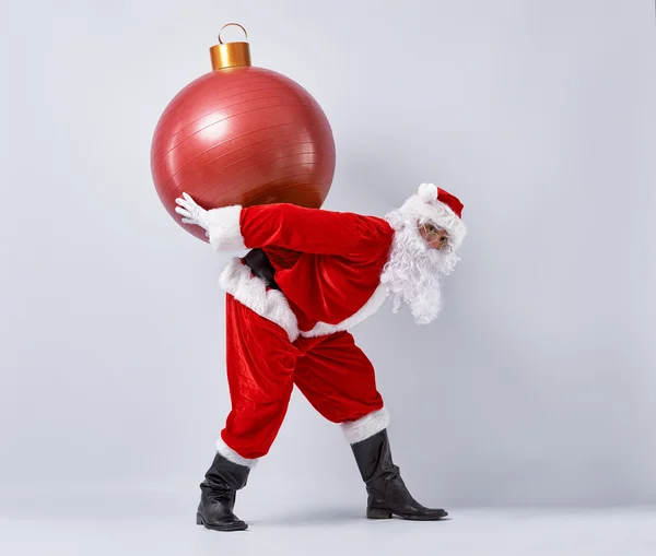 Weihnachtsmann mit Christbaumkugel. — Stockfoto