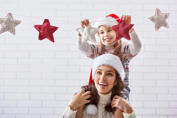 Mutter und Tochter hängen einen Kranz auf — Stockfoto