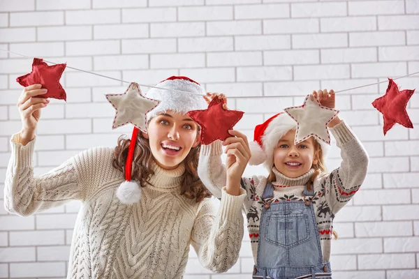 Mother and daughter hang a garland — Stock Photo, Image