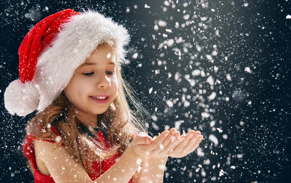 little girl catching snowflakes