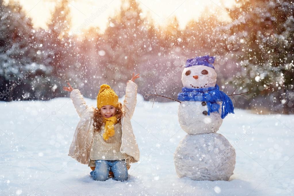 girl playing with a snowman