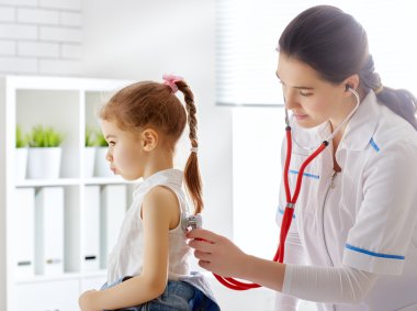 Bir çocuğu muayene eden doktor.
