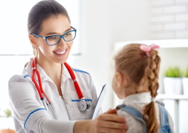 Bir çocuğu muayene eden doktor.