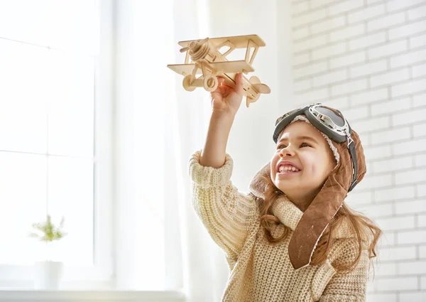 Flicka som leker med leksak flygplan — Stockfoto