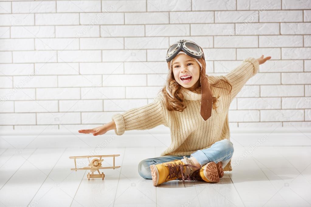 girl playing with toy airplane