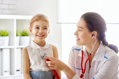 Bir çocuğu muayene eden doktor.