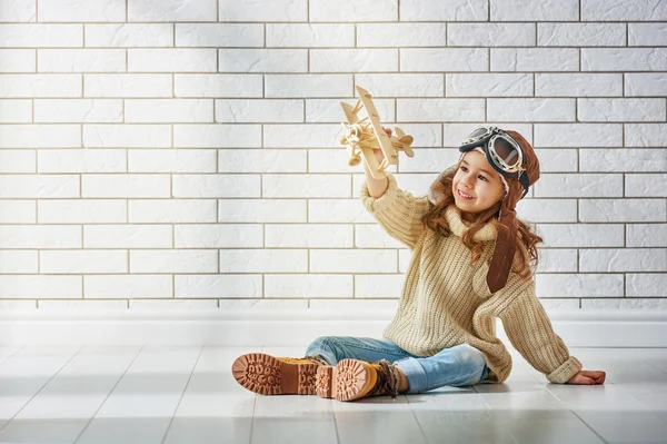Mädchen spielt mit Spielzeugflugzeug — Stockfoto