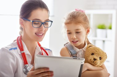 Bir çocuğu muayene eden doktor.