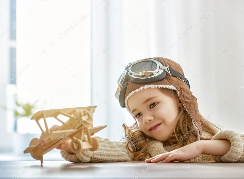 girl playing with toy airplane