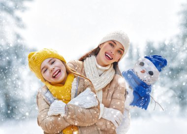 Mother and child girl on a winter walk clipart