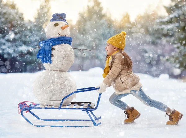 Mädchen, das mit einem Schneemann flechtet — Stockfoto