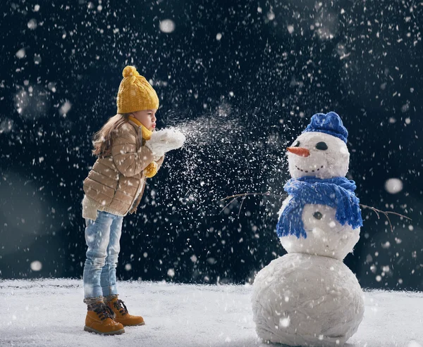 Mädchen, das mit einem Schneemann flechtet — Stockfoto