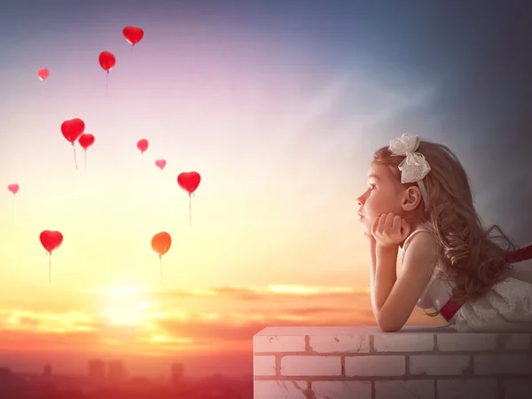 Girl looking at red balloons — Stock Photo, Image