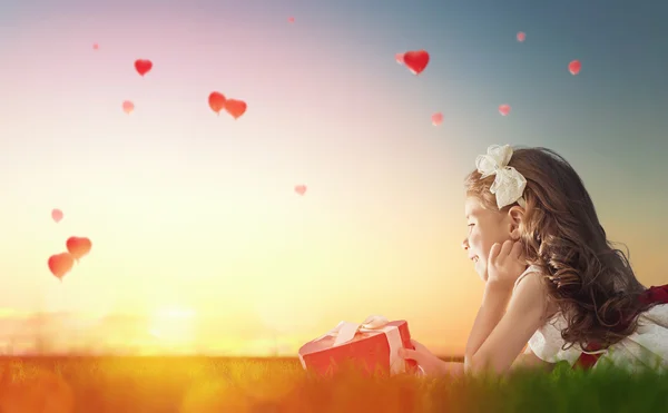 Girl looking at red balloons — Stock Photo, Image