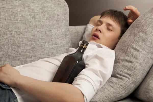 A man with a drinking problem is relaxing on a sofa — Stock Photo, Image