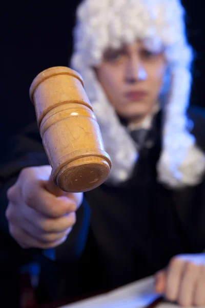 Male judge in a courtroom striking the gavel — Stock Photo, Image