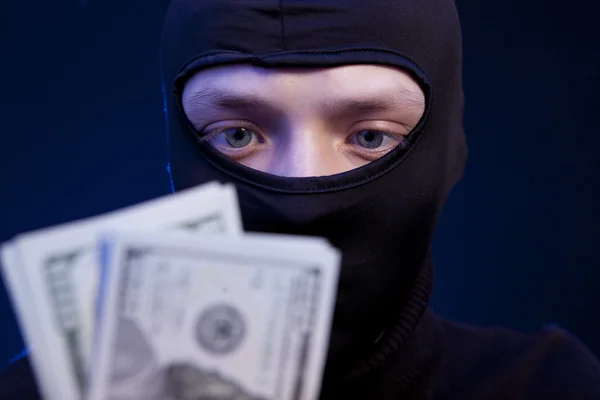 Man in black mask holding the money — Stock Photo, Image