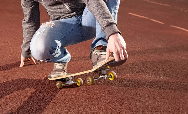 Adolescente haciendo ejercicios en un monopatín — Foto de Stock