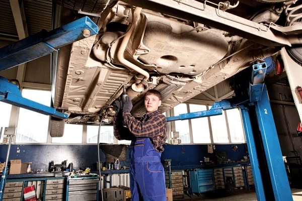 Mechanik samochodowy pracujący w serwisie naprawy samochodów — Zdjęcie stockowe