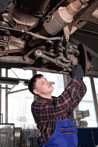 Mecánico del coche que inspecciona rueda del coche y detalle de la suspensión del lifte — Foto de Stock