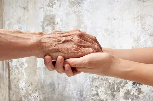 Manos de un anciano sosteniendo la mano de una mujer — Foto de Stock