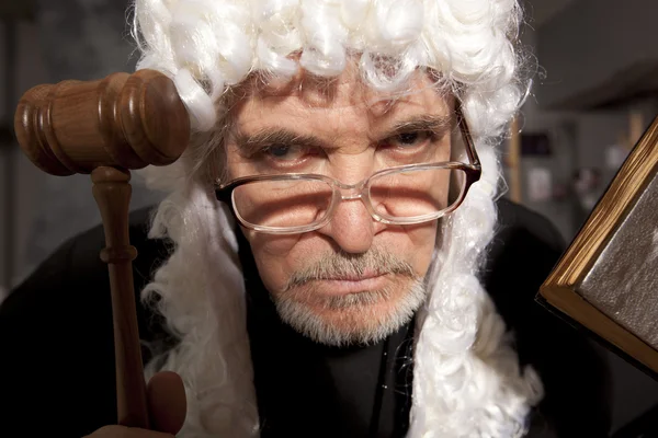 Velho juiz em um tribunal golpeando o martelo — Fotografia de Stock