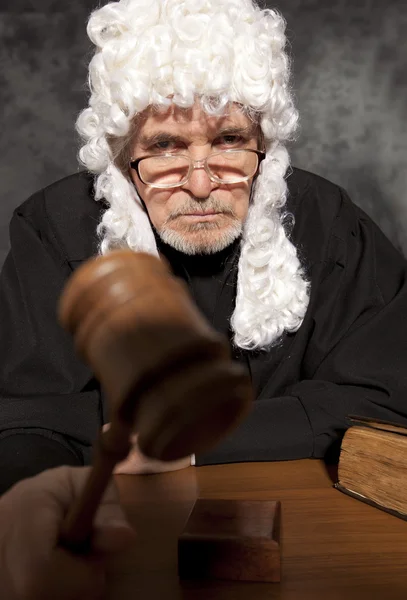 Old male judge in a courtroom striking the gavel — Stock Photo, Image