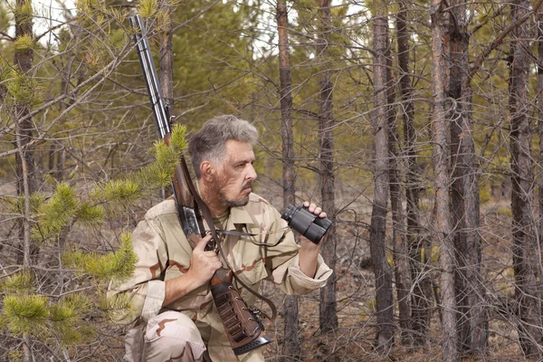 Hunter z shotguna patrząc przez lornetki — Zdjęcie stockowe