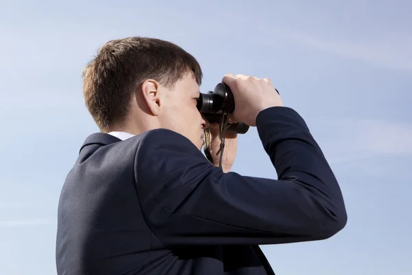 Homme d'affaires regarde à travers une jumelle — Photo